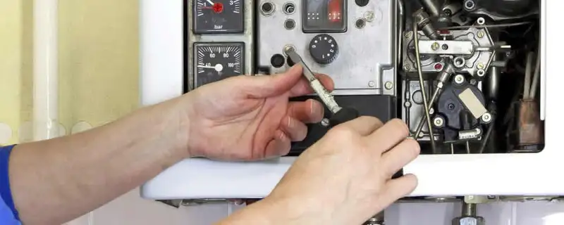 Heating repair technician adjusting boiler controls and components in Troy, MI