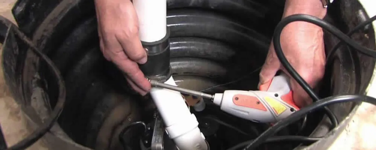 Sump pump installation technician connecting PVC discharge piping in Troy, MI