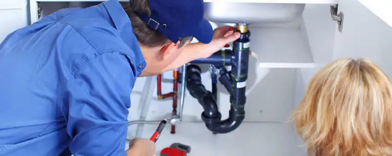 Plumber repairing under-sink drain pipes and fittings in Troy, MI